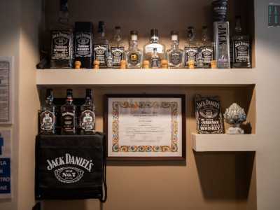 ...delle bottiglie di whisky poggiate su una mensola. In America infatti durante l�epoca del proibizionismo l�alcol veniva venduto clandestinamente proprio all�interno delle botteghe dei barbieri